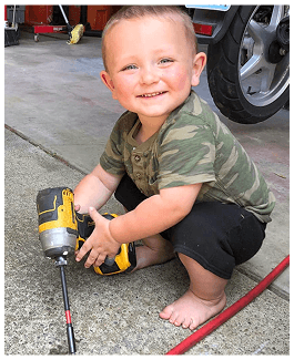 Aaron's son holding a drill
